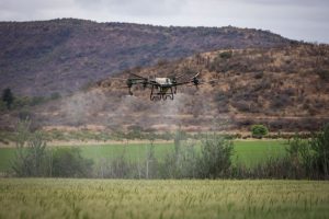 Agricultural drone used for smart farming flying over a green field